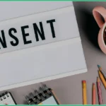 consent management mentioned on a paper near by a cup of coffee and pencils
